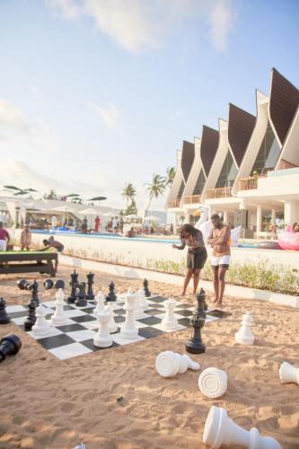 twee mensen die schaken op een schaakbord op het strand bij YOLO Island Resort 