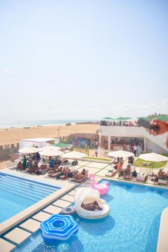 een zwembad van het resort met een strand op de achtergrond bij YOLO Island Resort 