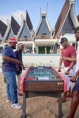 a group of men standing around a pool table at YOLO Island Resort 