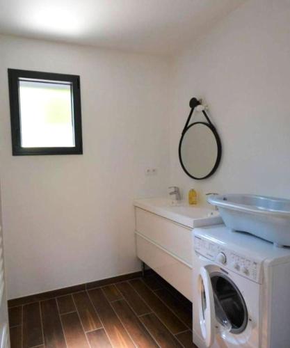 - une buanderie avec un lave-linge et un évier dans l'établissement Maison CLAPAS, à Saint Alban Auriolles