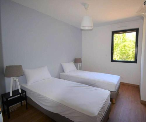 une chambre d'hôtel avec deux lits et une fenêtre dans l'établissement Maison CLAPAS, à Saint Alban Auriolles