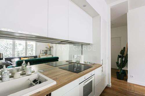 a kitchen with white cabinets and a counter top at Appartement 50m2 avec terrasse idéalement situé in Boulogne-Billancourt