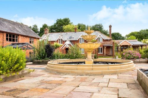 a fountain in the yard of a house at Oak Cottage - Great Houndbeare Farm Holiday Cottages in Aylesbeare