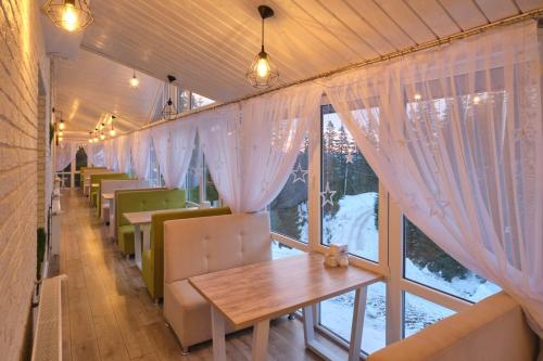 eine Reihe von Tischen und Stühlen in einem Restaurant in der Unterkunft Diamant Dragobrat in Drahobrat