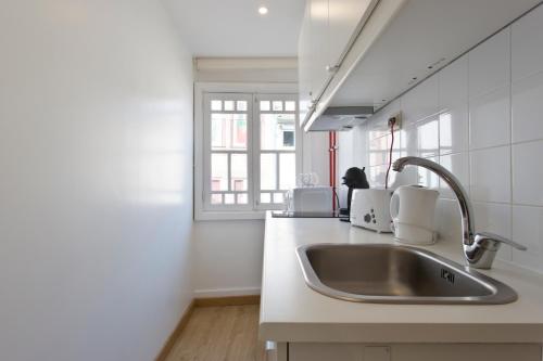 a kitchen with a sink and a window at Home @ Porto Clérigos Apartment in Porto