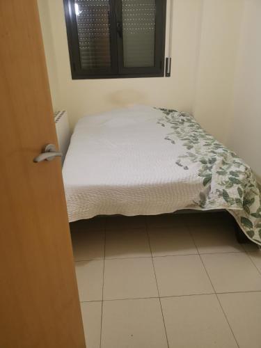 a small bed in a small room with a bedspread at one Room in Almenar