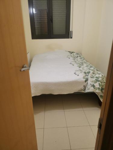 Ce petit lit se trouve dans une chambre dotée d'un sol blanc. dans l'établissement one Room, à Almenar
