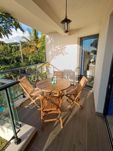 a patio with a table and chairs on a balcony at Résidence Amarosa in Les Avirons
