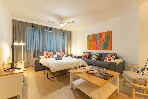 a living room with a bed and a couch at Charming 2 Bedroom Apartment by Torre Del Oro By Oui Sevilla in Seville