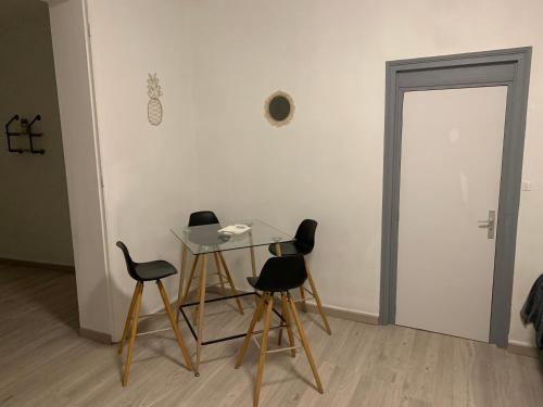 - une table et des chaises dans une pièce avec porte dans l'établissement Karim, à Sin-le-Noble