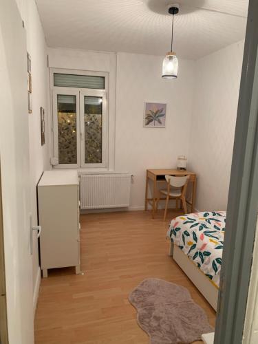 une chambre avec un lit et une table dans une pièce dans l'établissement Karim, à Sin-le-Noble