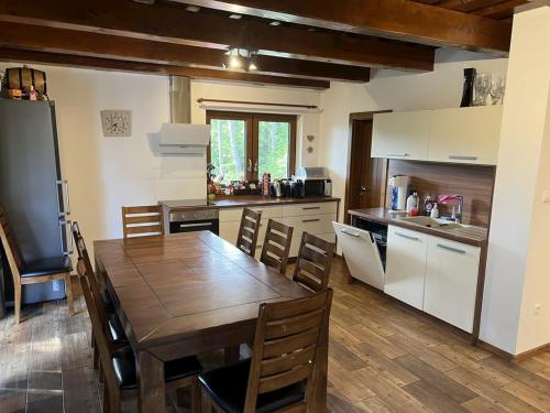 a kitchen with a wooden table and a wooden floor at Chata Matej in Námestovo