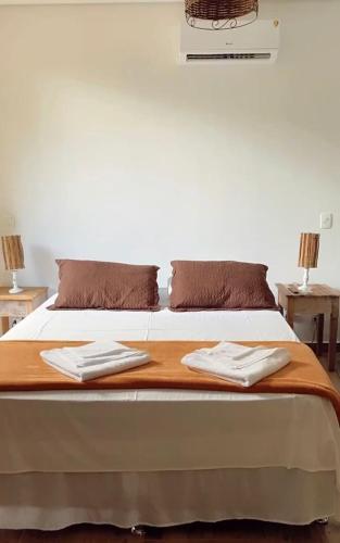 a bed with two towels on top of it at Pousada Pé da Mata Maresias in Maresias