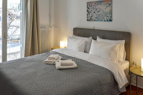 a bedroom with a bed with towels on it at Renovated Kypseli Apartment in Athens