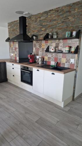 une cuisine avec des armoires blanches et un comptoir dans l'établissement Gîte le Cham'Oye, à Oye-et-Pallet