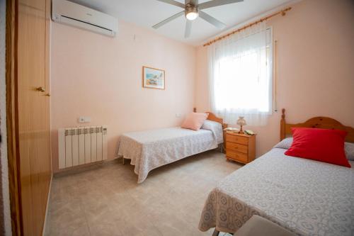 a bedroom with two beds and a window at Chalet individual con piscina privada en Miami Playa in Miami Platja