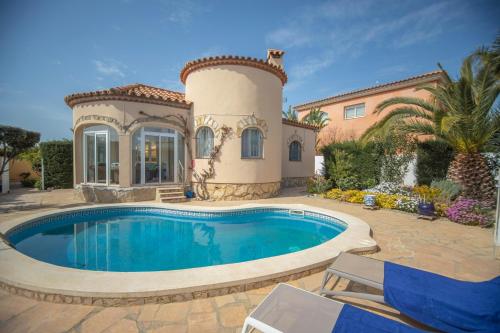 a villa with a swimming pool in front of a house at Chalet individual con piscina privada en Miami Playa in Miami Platja