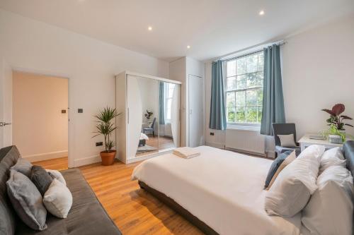 a large bedroom with a large bed and a couch at Spacious Two Bedroom Apartment in Camden by London Zoo in London