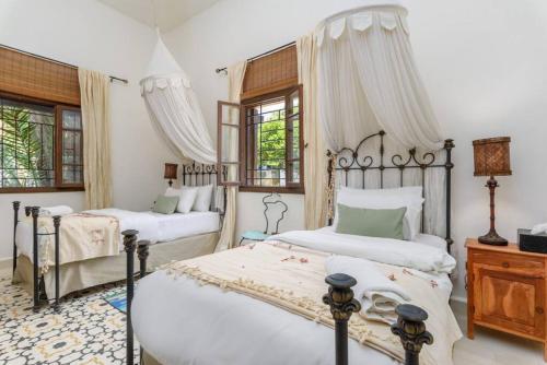 a bedroom with two beds and two windows at La Madrague 3 Bedroom Villa with Garden in Batroun in Batroûn