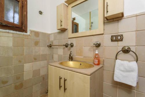 ein Bad mit einem Waschbecken und einem Spiegel in der Unterkunft La Madrague 3 Bedroom Villa with Garden in Batroun in Batrun
