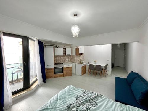 uma sala de estar e cozinha com um sofá azul num quarto em Solid Residence Sea View em Mamaia
