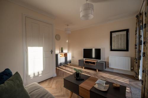 a living room with a couch and a tv and a door at Pottery Wharf By Horizon Stays in Thornaby on Tees