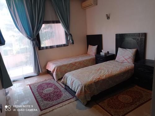 sypialnia z 2 łóżkami i oknem w obiekcie Appartement w Marakeszu