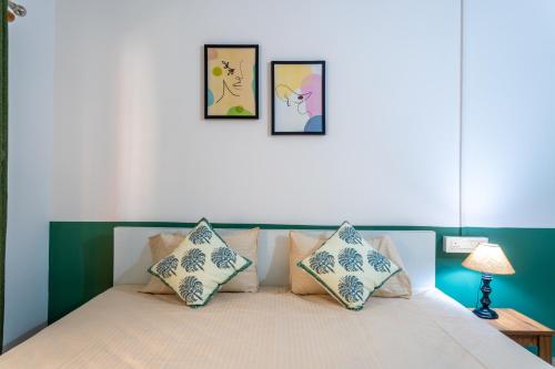 a bedroom with a bed with three pictures on the wall at Mulaqat Homestay in Siliguri