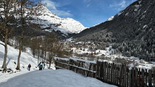 a group of people skiing down a snow covered mountain at Ferienwohnung Valere B - it's magic gmbh in Leukerbad