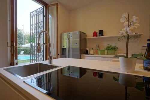 a kitchen with a sink and a counter with a window at Villa Lilli con piscina riscaldata in Montecatini Terme