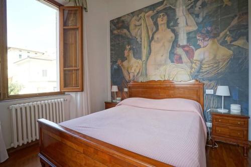 a bedroom with a bed with a painting on the wall at Villa Lilli con piscina riscaldata in Montecatini Terme