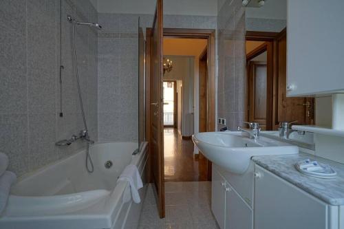 a bathroom with a tub and a sink and a bath tub at Villa Lilli con piscina riscaldata in Montecatini Terme