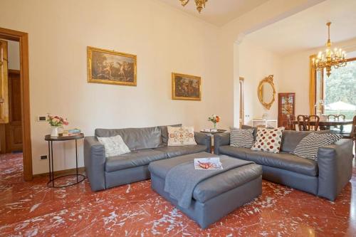 a living room with two couches and a table at Villa Lilli con piscina riscaldata in Montecatini Terme