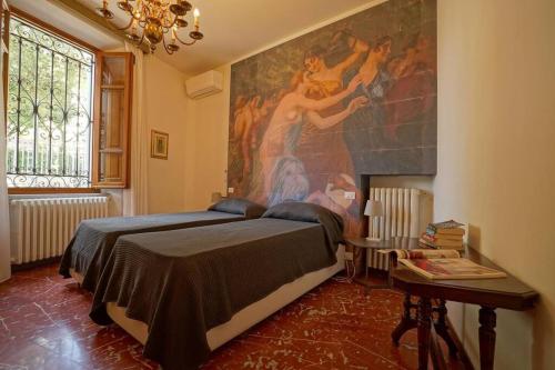 a bedroom with a large painting on the wall at Villa Lilli con piscina riscaldata in Montecatini Terme