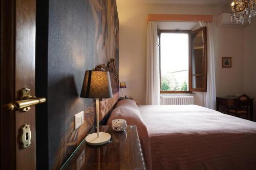 a bedroom with a bed and a table with a lamp at Villa Lilli con piscina riscaldata in Montecatini Terme