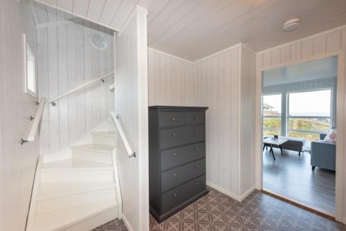 une chambre avec un escalier et une commode à côté d'une chambre dans l'établissement Moderne hytte på fantastiske Gimsøy i Lofoten, à Gimsøy