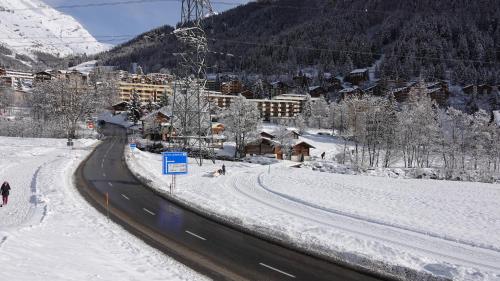 a snow covered street next to a ski resort at Ferienwohnung Valere B - it's magic gmbh in Leukerbad