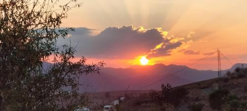 a sunset in the mountains with the sun setting at Bed & Breakfast Casa Ceratonia in Alora