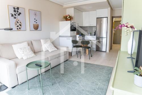 Una sala de estar con un sofá blanco y una mesa. en Cimadevilla, en Oviedo
