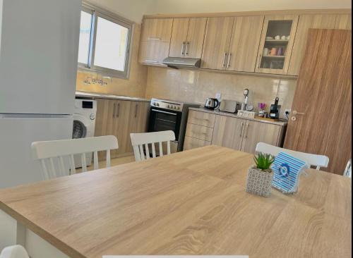 a kitchen with a wooden table and a table and chairs at Urban Retreat - Your Ideal Getaway in Limassol in Limassol