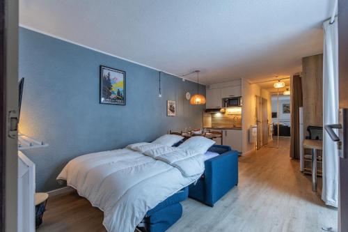 sypialnia z łóżkiem i niebieską ścianą w obiekcie Le Bastan - Appt pour 4 avec Jardin w mieście Barèges