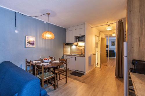 une cuisine et une salle à manger avec une table dans une pièce dans l'établissement Le Bastan - Appt pour 4 avec Jardin, à Barèges