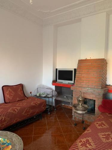 sala de estar con sofá y chimenea en Maison vallée de l'Ourika en Marrakech