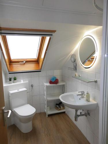 a bathroom with a toilet and a sink and a window at Ferienwohnung Elgas in Habscheid
