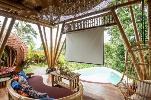 eine abgeschirmte Veranda mit einem Bildschirm und einem Pool in der Unterkunft Magical Bamboo House with Breathtaking view in Selat