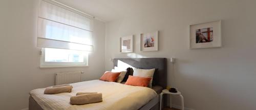 um quarto com uma cama com almofadas laranja em Delux apartment LA ARENA with private garage em Zagreb