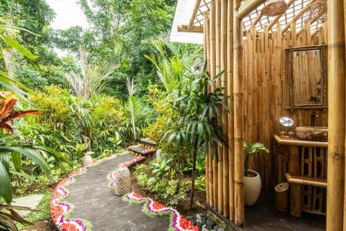 einen Garten mit einem hölzernen Gehweg mit Pflanzen in der Unterkunft Magical Bamboo House with Breathtaking view in Selat