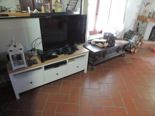 a living room with a large flat screen tv on a cabinet at Il Paiolo Incantato in Bracciano
