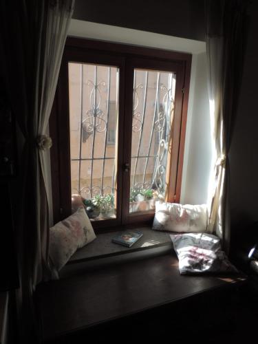 a window seat with pillows and a window with a gate at Il Paiolo Incantato in Bracciano