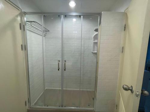 a shower with a glass door in a bathroom at Grand Residence in Bangkok